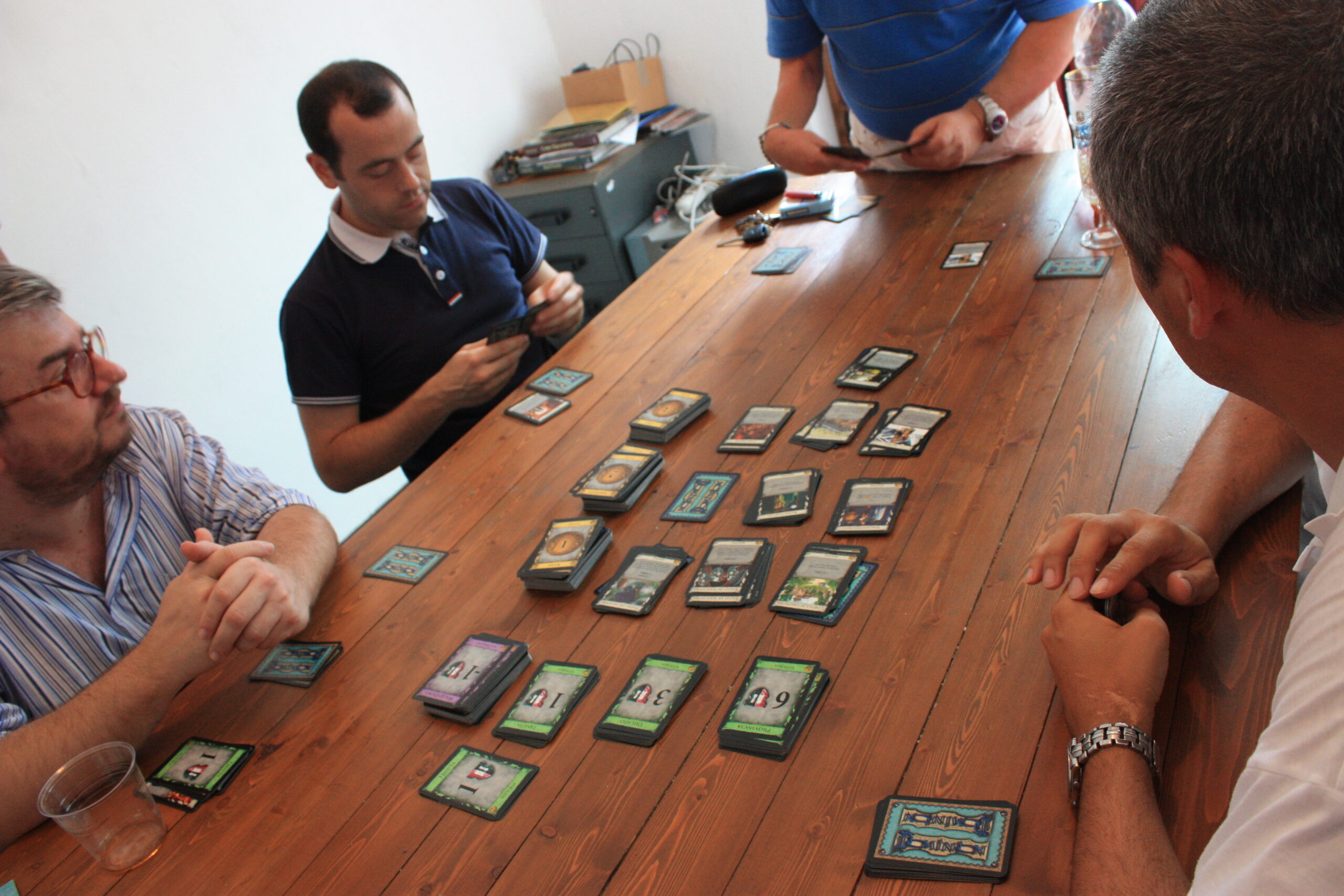 Dominion deck-building card game in play (Wikimedia Commons, CC BY-SA 3.0). Illustrative of deckbuilders like Friday.