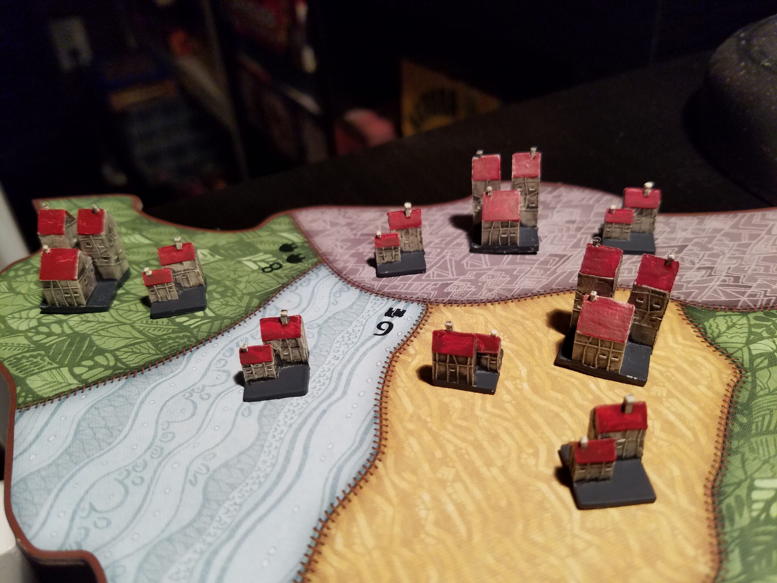 Spirit Island board game: painted buildings and components on the table (Wikimedia Commons, CC0).